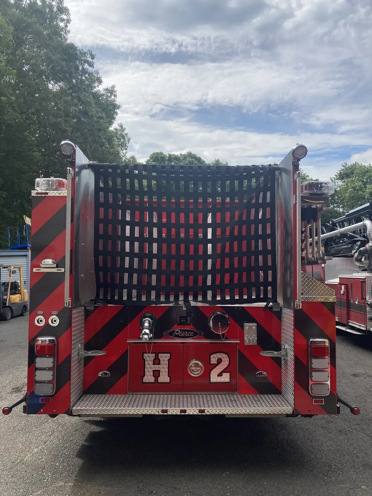Rear view showing hosebed netting, chevrons, and rear discharge panel