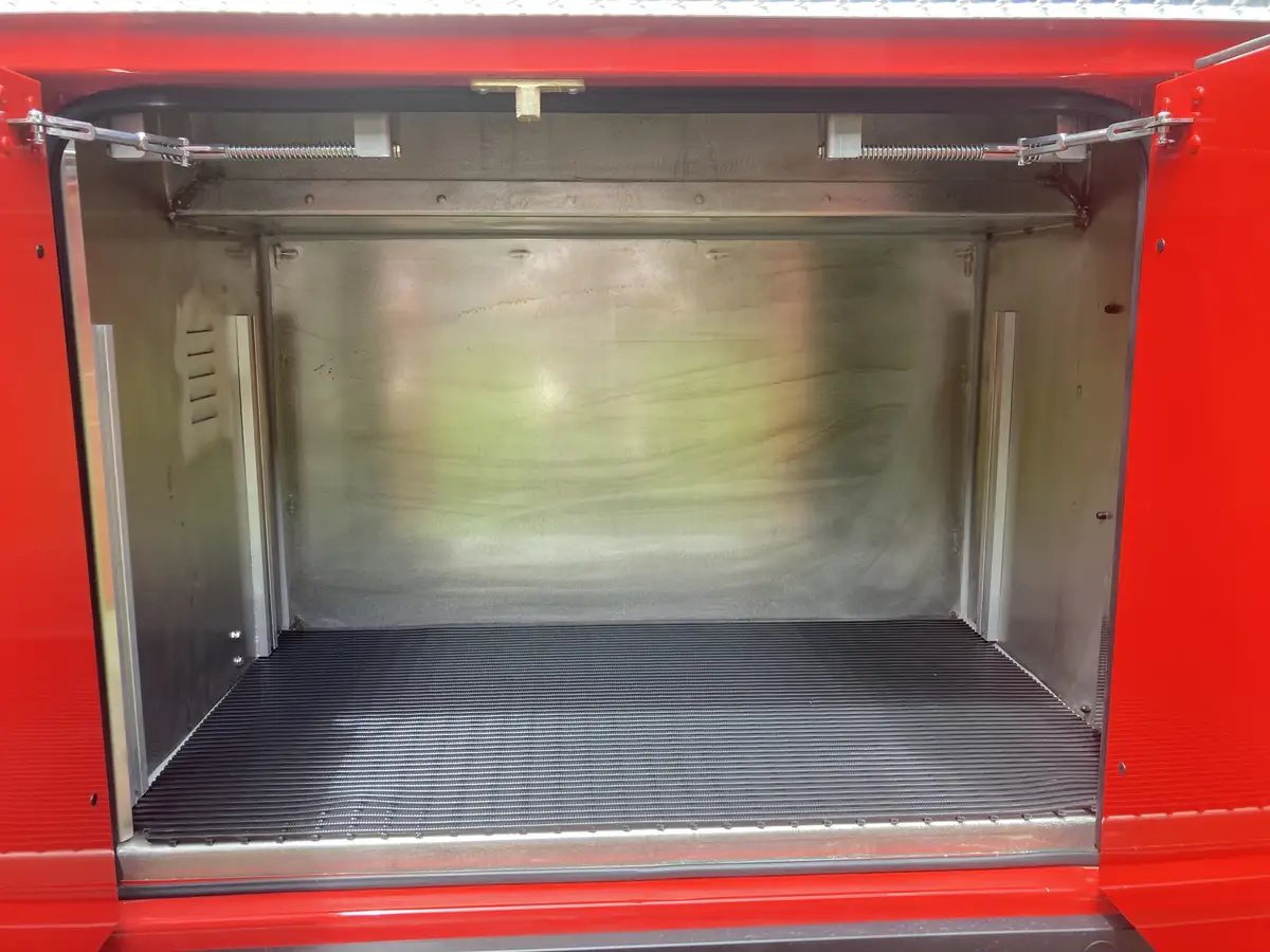 Empty side compartment interior with ribbed floor and stainless walls