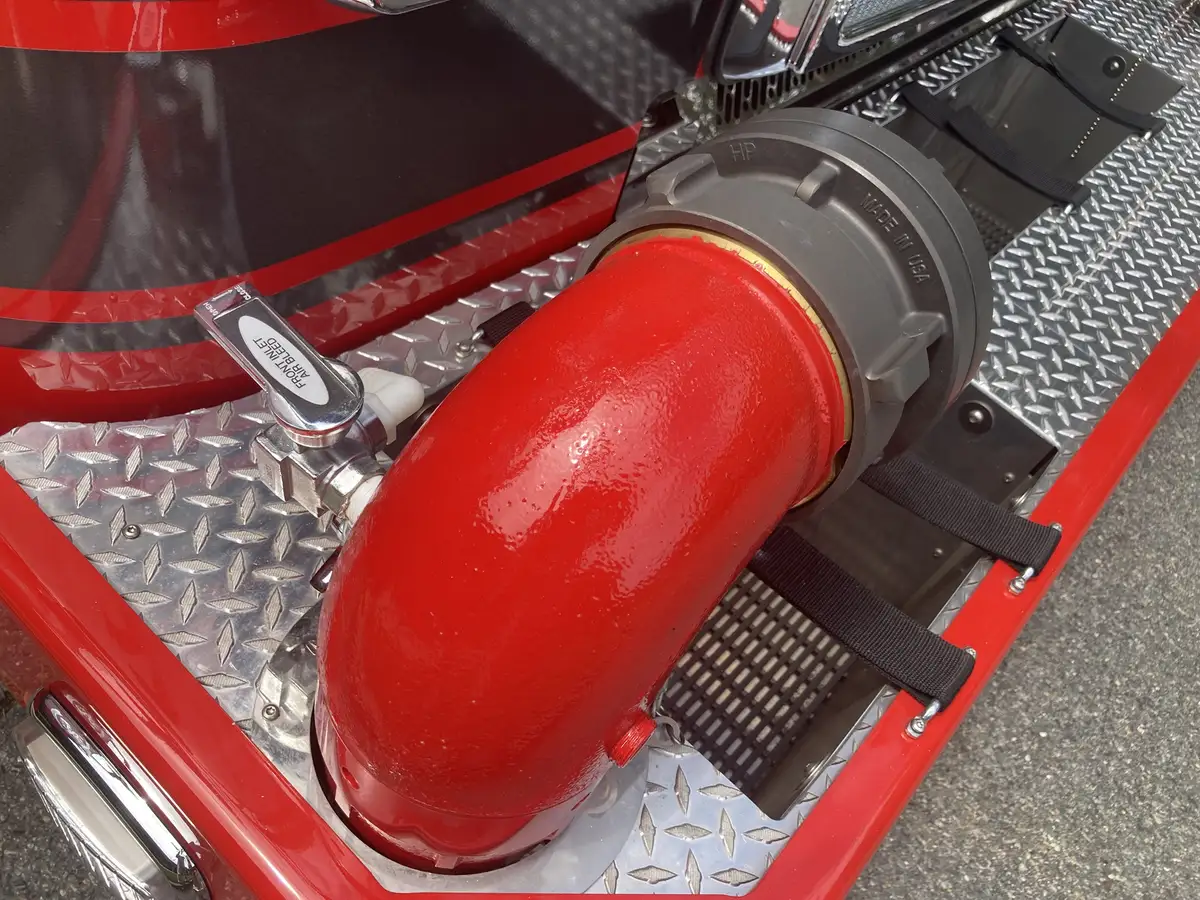 Bumper-mounted chrome siren close-up on diamond-plate deck