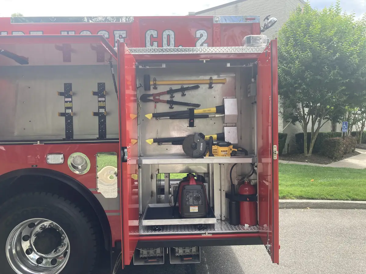 Tool compartment close-up showing mounted hand tools and circular saw