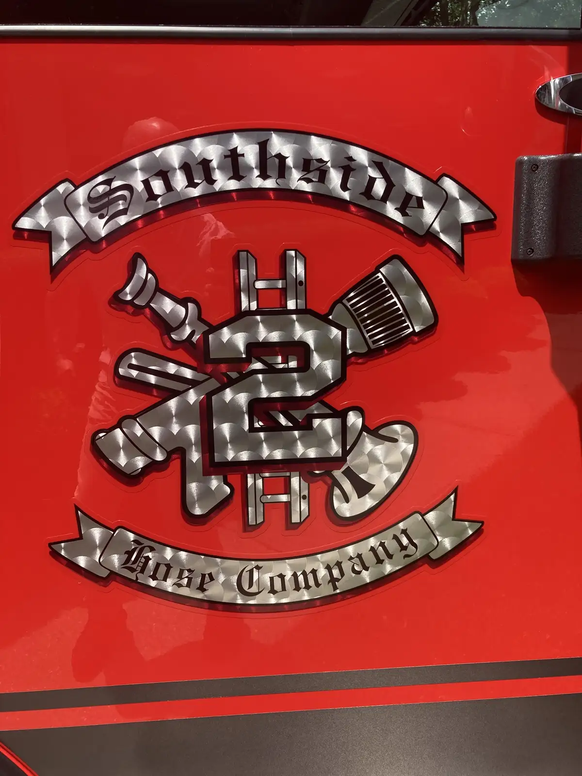 Vintage fire engine mural decal close-up on red door panel