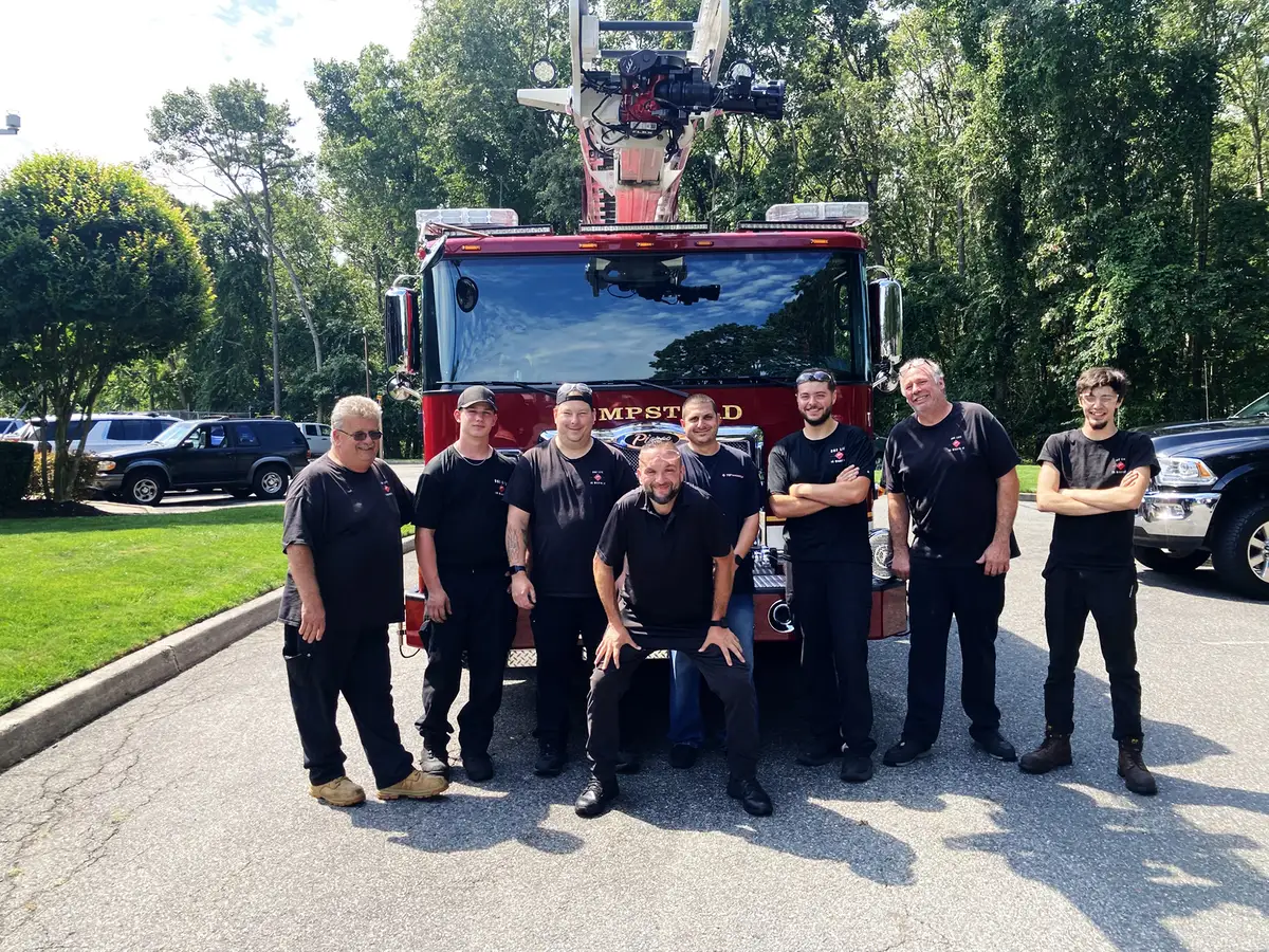 Aerial ladder truck front-left exterior view showing bumper, cab, and ladder sections above