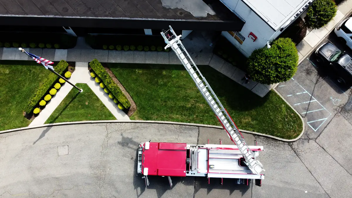 Aerial ladder truck officer-side profile showing body compartments and rear wheel area