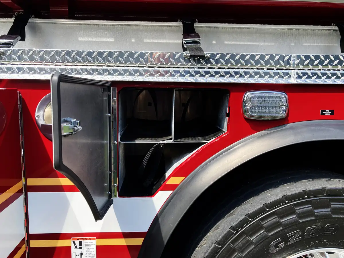 Open compartment near rear wheel showing adjustable shelving and storage brackets