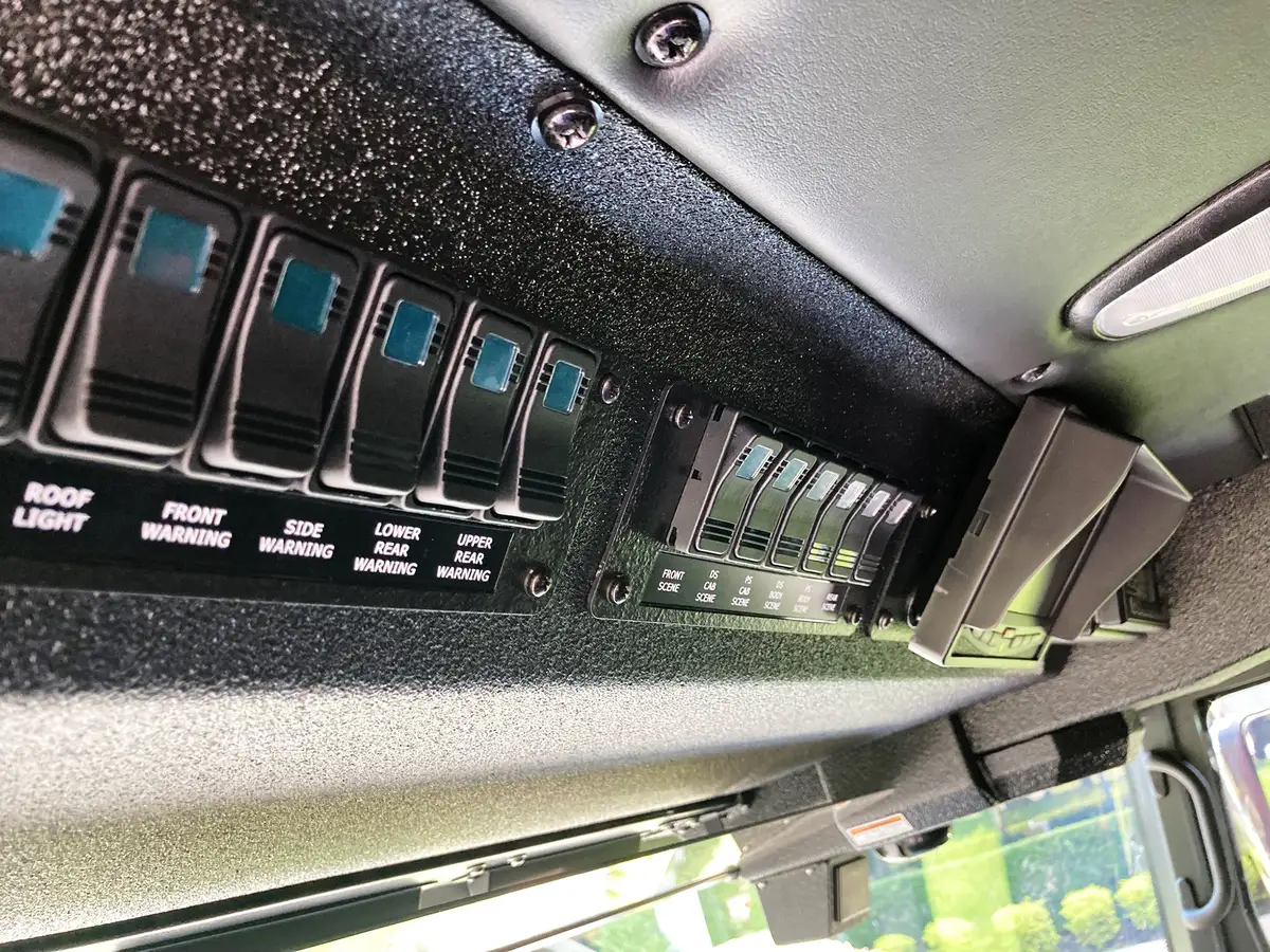 Cab overhead console close-up showing toggle switches and control labels