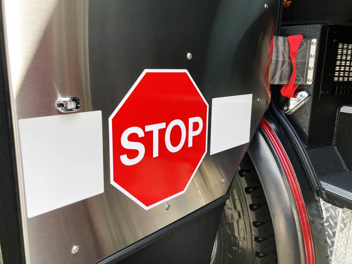 Driver door interior view showing grab handle, controls, and side mirror frame