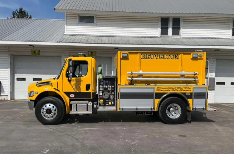 Driver-side full profile view showing pump panel and hard suction tube mount