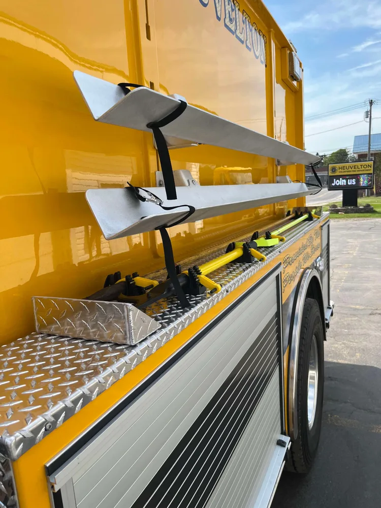 Side detail view showing mounted hard suction tubes and long-handled tools