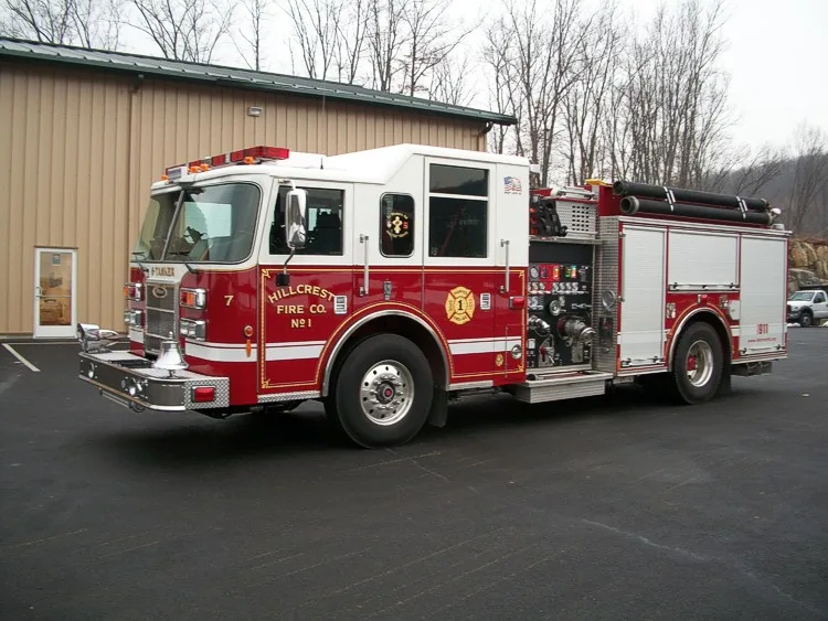 Front left side angle showing cab doors, pump controls, side compartments, and top hose storage.