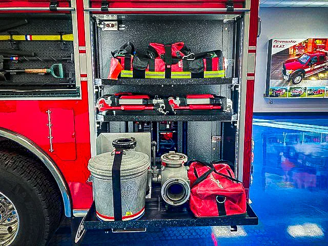 Open side compartment showing tools, bags, and shelf-mounted equipment