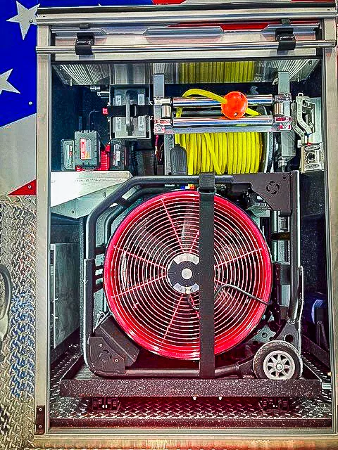 Open side compartment showing ventilation fan and stored equipment bins