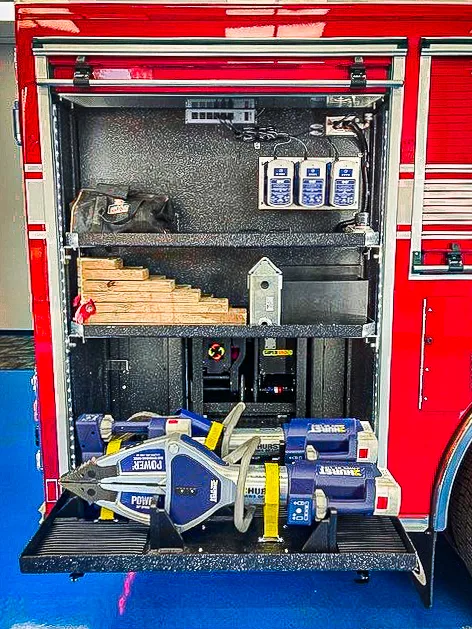 Open side compartment showing portable saw and tool storage shelves