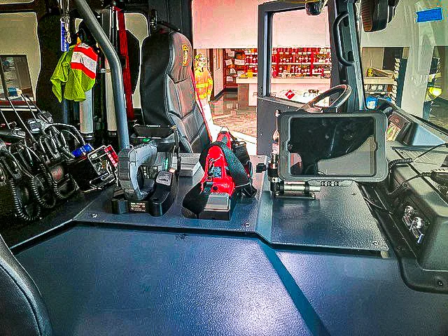 Cab interior view showing center workspace, mounted equipment, and front seats
