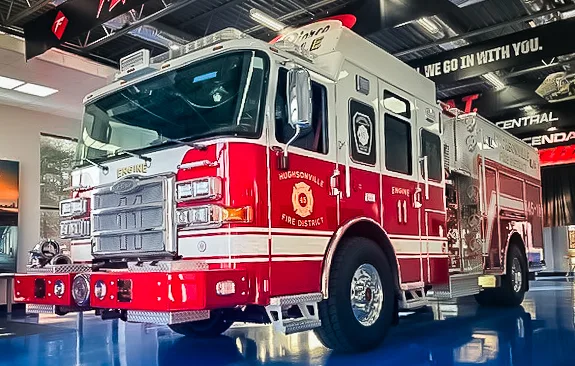 Pumper front-left exterior view parked in apparatus bay with side profile visible