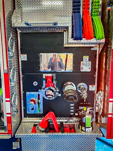 Open side compartment showing drawers and mounted tools in lower bay