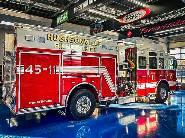 Driver-side profile showing pumper body, wheel area, and unit lettering