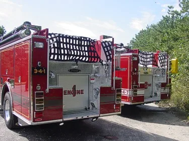 Rear view of two apparatus showing hosebed rails and rear panels