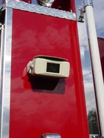 Body-side camera close-up mounted on red panel next to grab rail