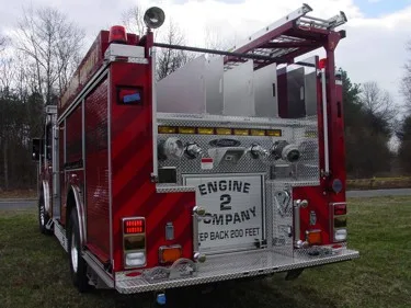 Rear view showing rear body panel, hose connections, and ladder rails