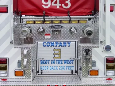 Rear lower panel close-up showing warning plate and hose connections