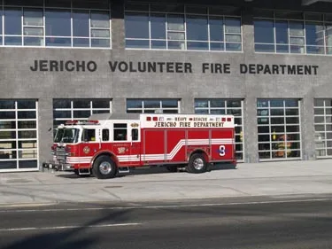 Front station view showing heavy rescue truck parked near bay doors