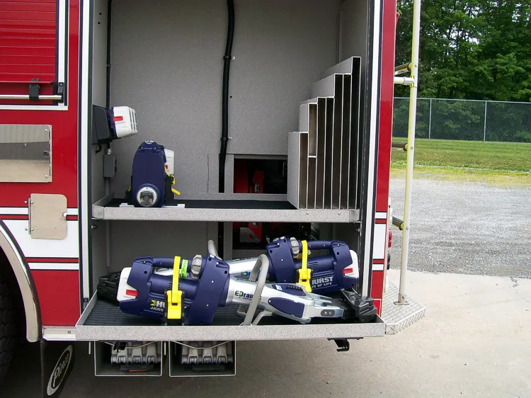Open side compartment showing multiple strapped soft bags on pull-out tray
