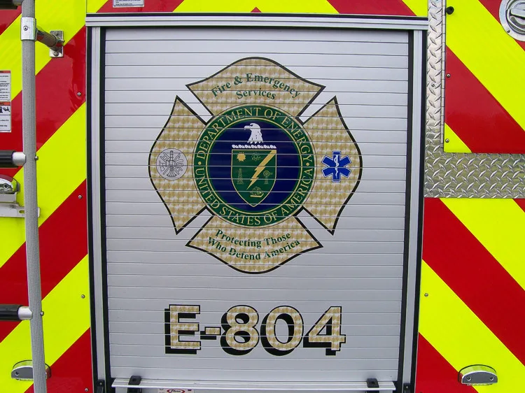 Rear door close-up showing crest emblem and reflective striping