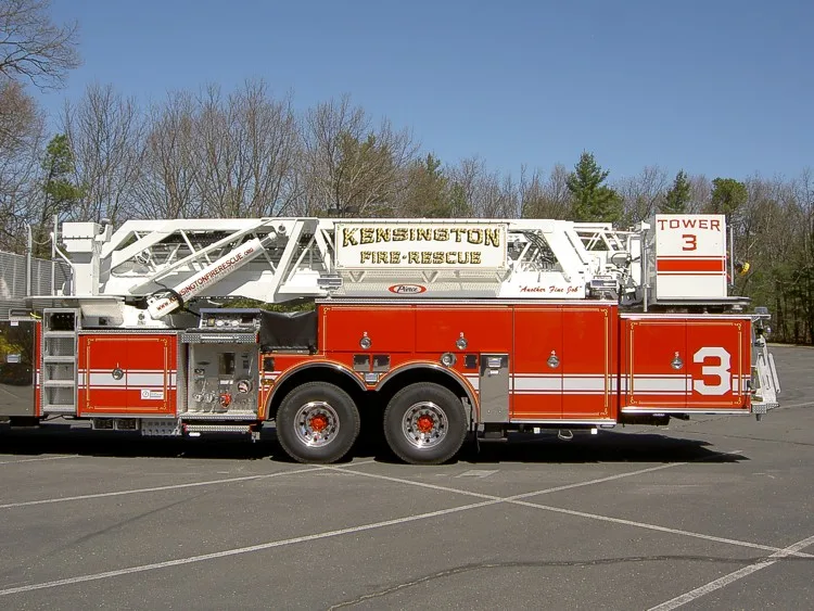 Full left-side profile with stowed aerial ladder, turntable area, side pump controls, and tandem wheel section.