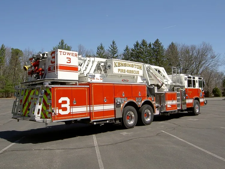 Rear left side view highlighting the bucket at the tail, stabilizer area, and side compartment doors.