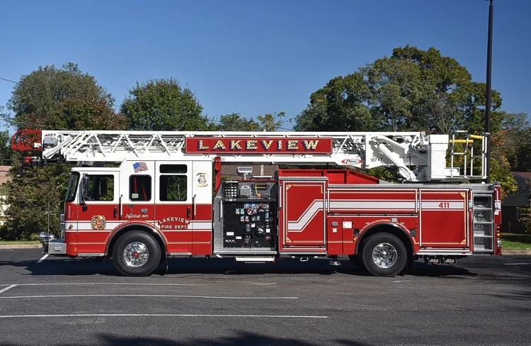 Driver-side full profile showing pump panel, side body, and rear tiller platform area