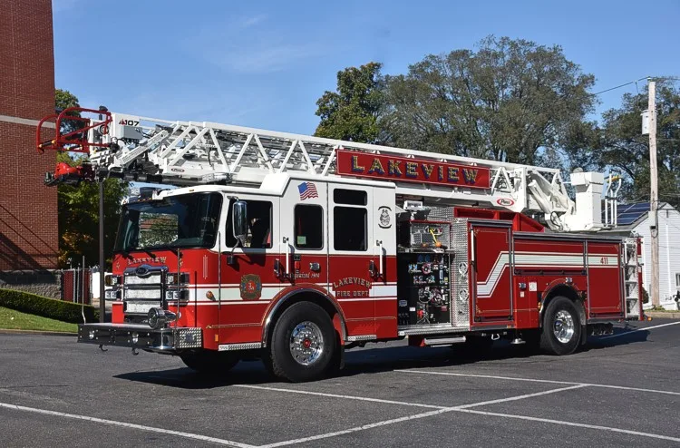 Front-left exterior profile showing aerial ladder, cab, and side pump panel