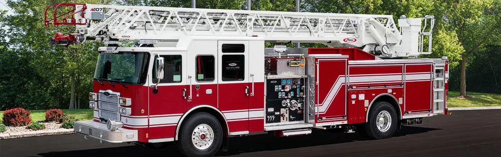 Passenger-side profile view of aerial ladder truck with ladder stowed above cab