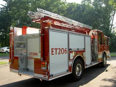 Rear left side view showing roll-up compartments, ladder rack on top, and rear corner compartment area.