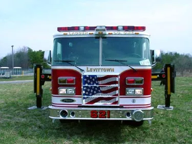 Head-on front view showing grille, bumper, and deployed outrigger arms