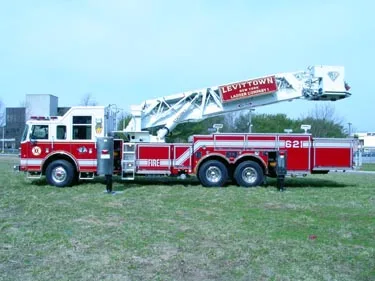 Driver-side profile showing tower ladder stowed low with outriggers extended