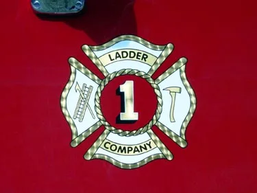 Maltese-cross emblem close-up on red body panel