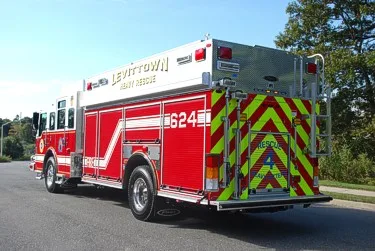 Rear-right exterior view showing red-yellow chevrons and rear body ladder