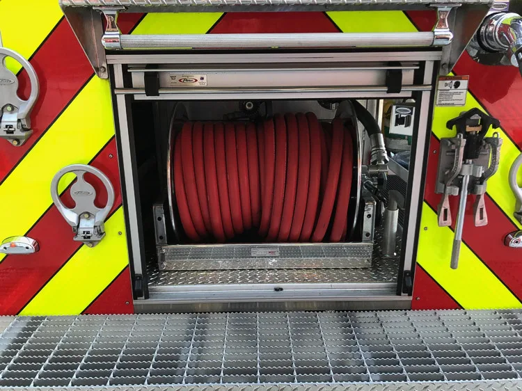 Rear hose reel close-up showing red hose roll in open rear compartment