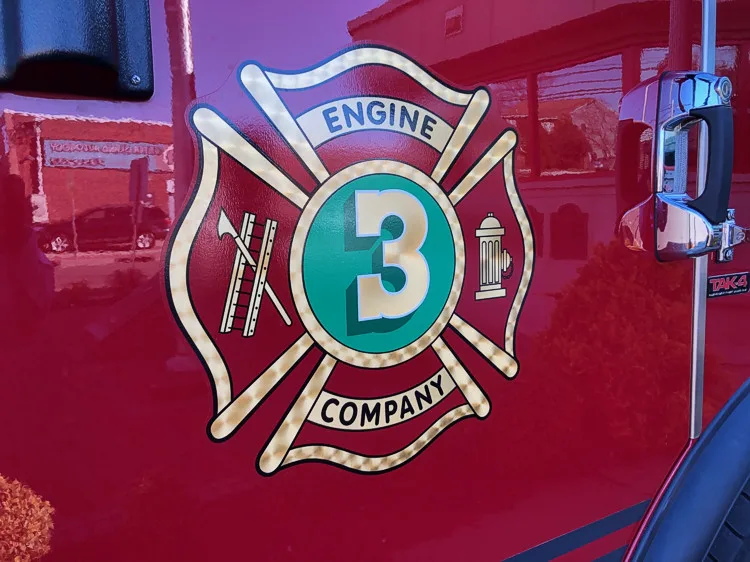 Cab door close-up showing a Maltese-cross style company crest