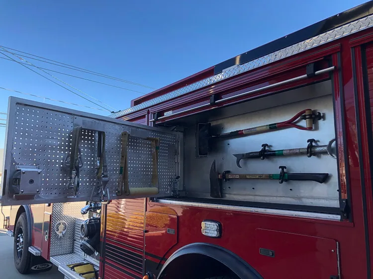 Open side compartment showing mounted long tools and shelf storage