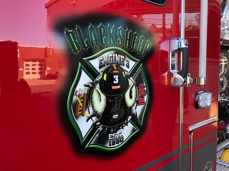 Cab door close-up showing shield-style firefighter artwork on red panel