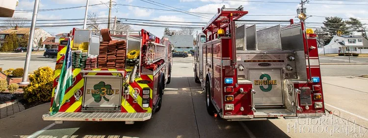 Rear equipment lineup view showing multiple apparatus hosebeds and chevron tails