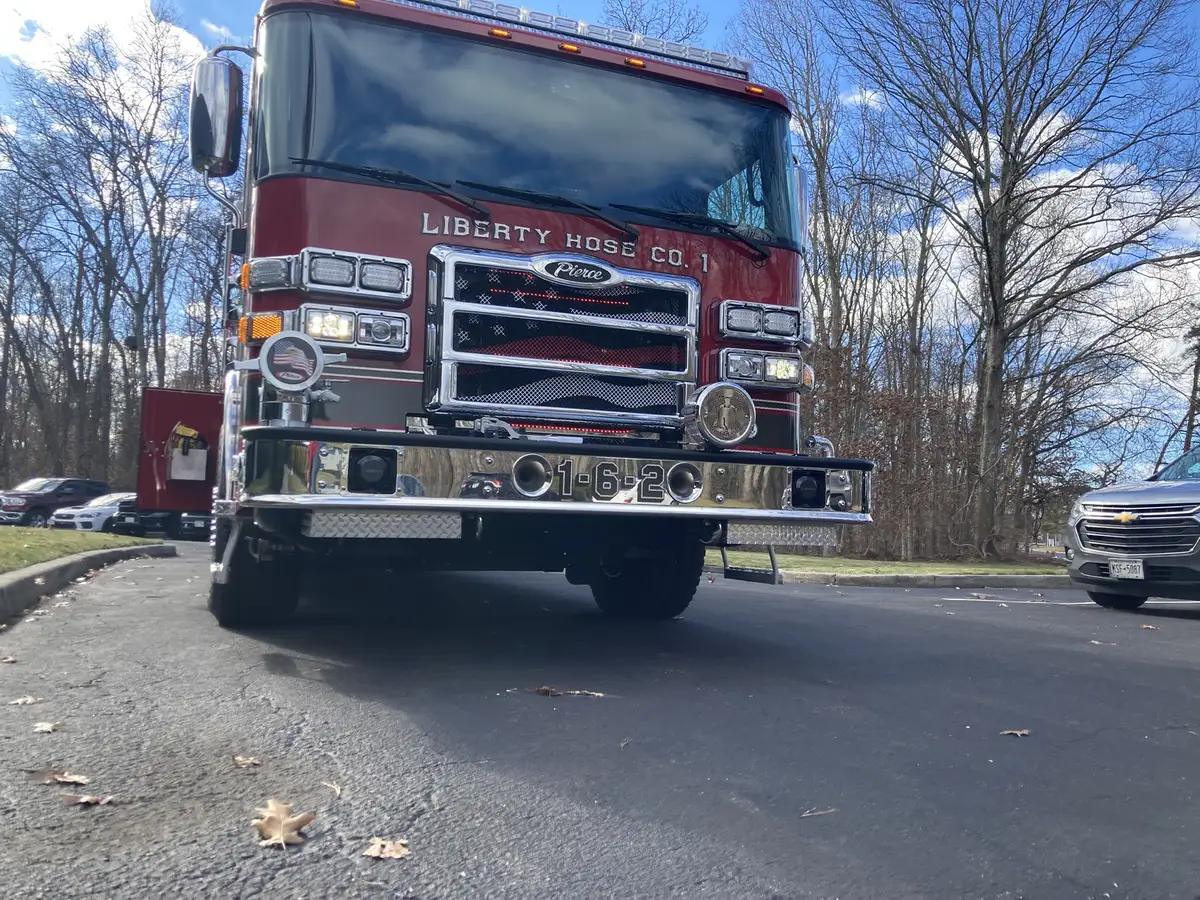 Front-left exterior view showing cab, front wheel, and side striping