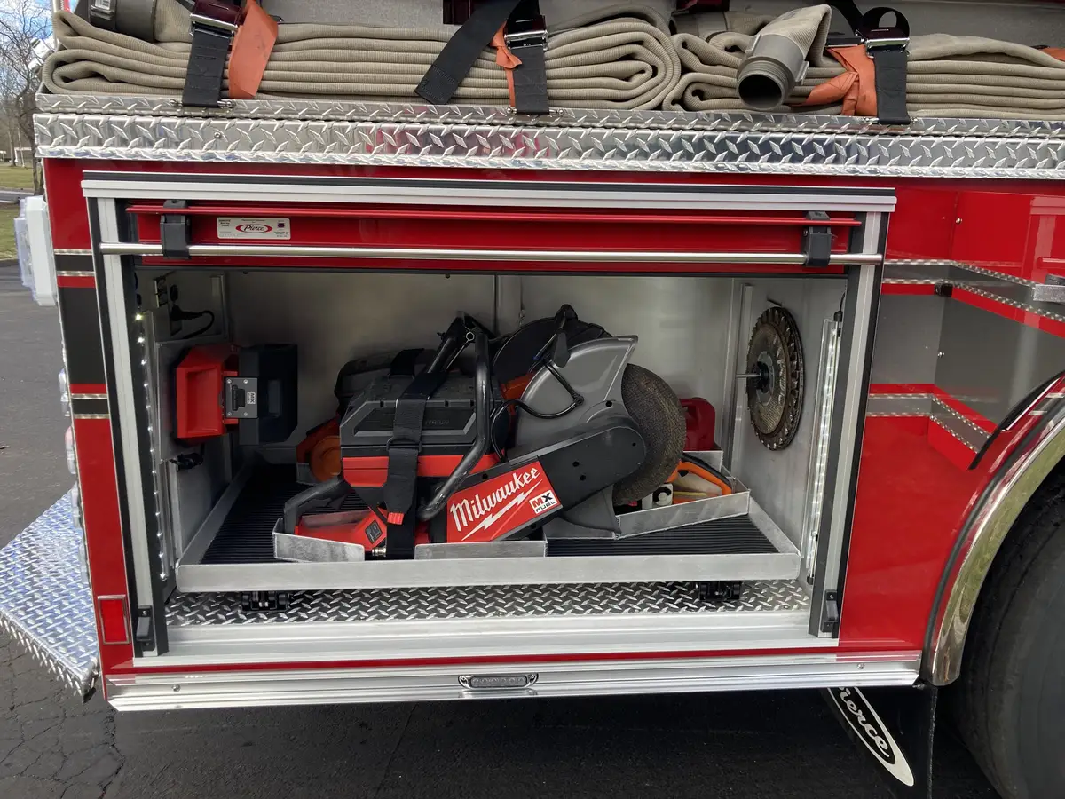 Open side compartment showing rescue tools, saw storage, and utility shelves