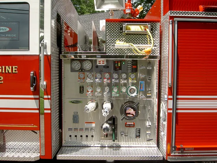 Close-up of the pump panel with pressure gauges, intake controls, valve handles, and switch labels.