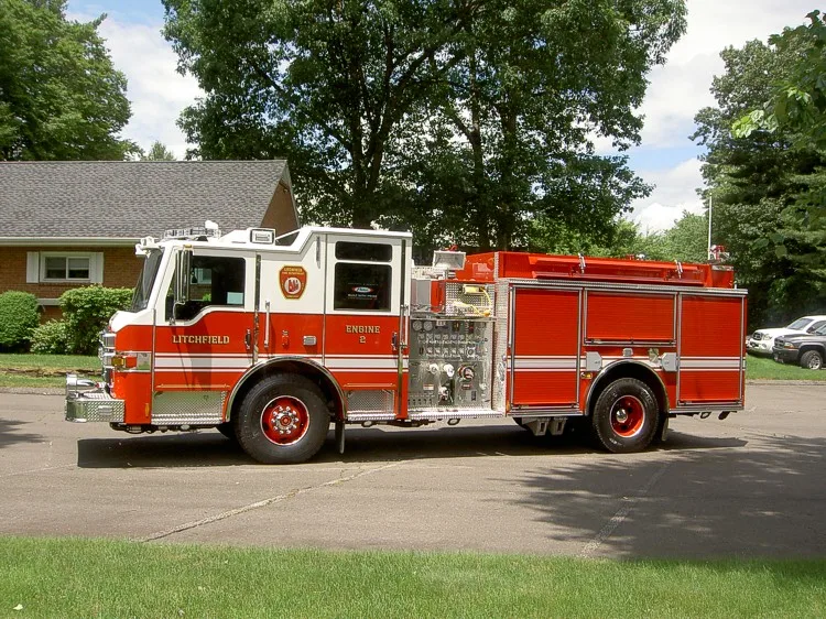 Full left-side profile showing pump panel position, compartment layout, and wheel/tire areas.