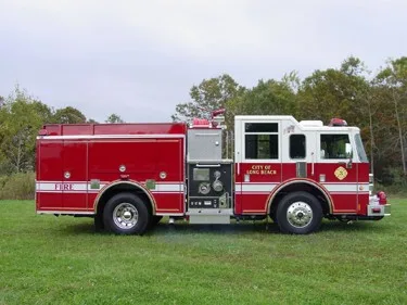 Driver-side profile view showing exposed pump panel, side compartments, and wheel area