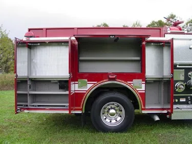 Driver-side compartment view with doors open showing storage shelves and wheel area