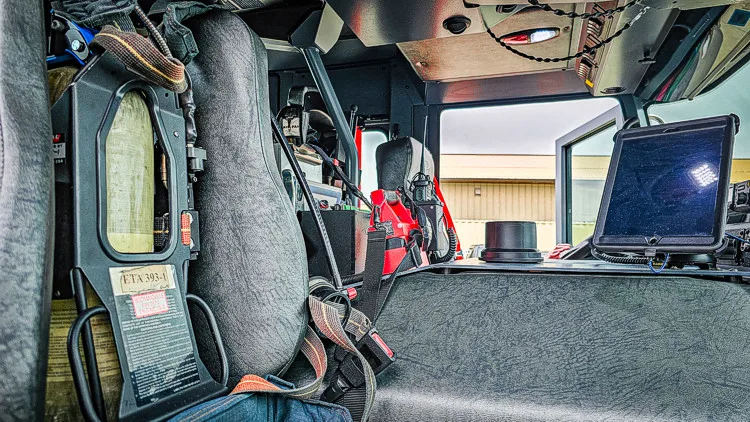 Cab interior side view showing rear seats and side equipment rack