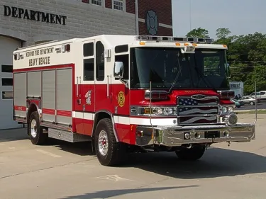 Front right angle showing the cab, chrome bumper, and rescue body compartments along the side.